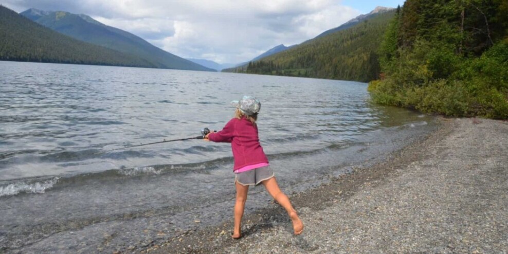 kid casts fishing line into water