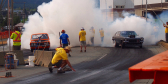 A mess of people, smoke, and muscle cars at the 2018 Thunder in the Valley.